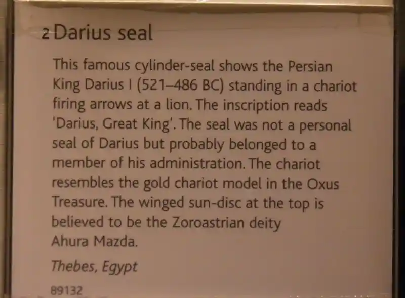 Winged man, sun-disc on top of a chariot of king Darius firing arrows at a lion on the Darius seal